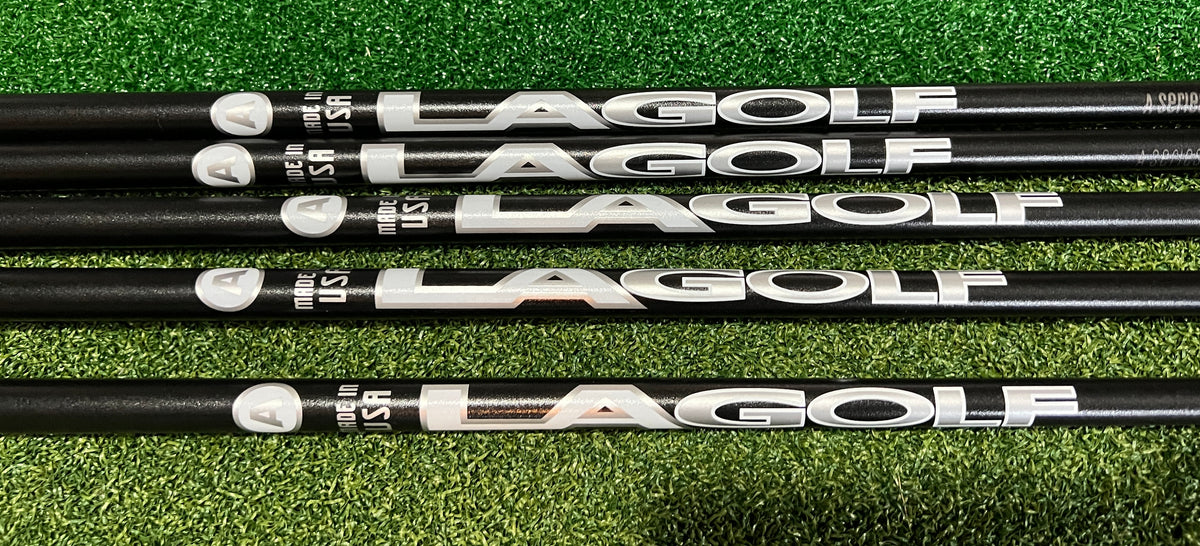 Four black Lagolf golf club shafts with silver and white branding, laid horizontally on a green artificial turf background.